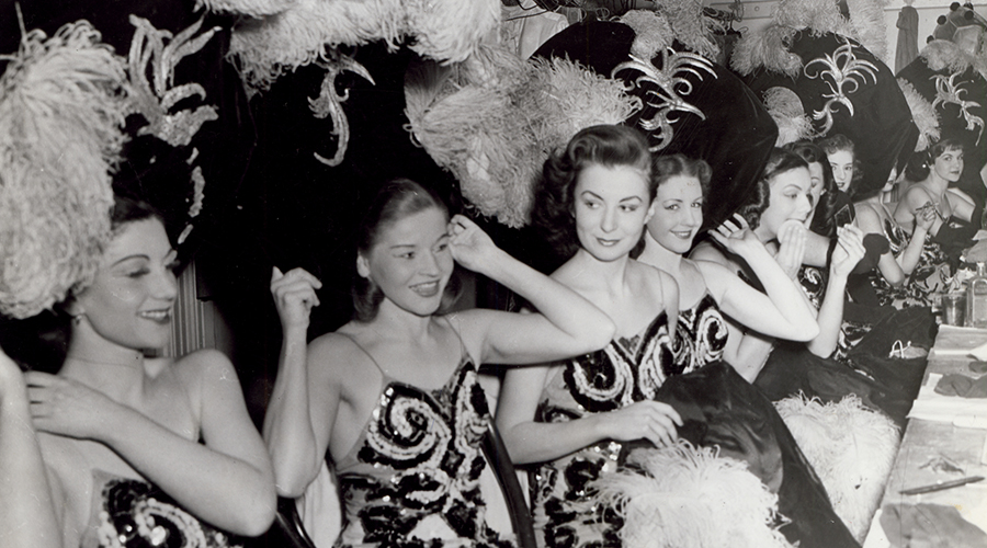 Dancers at the Tivoli Theatre, Melbourne, c.1955. They are fixing their headdresses and smiling.