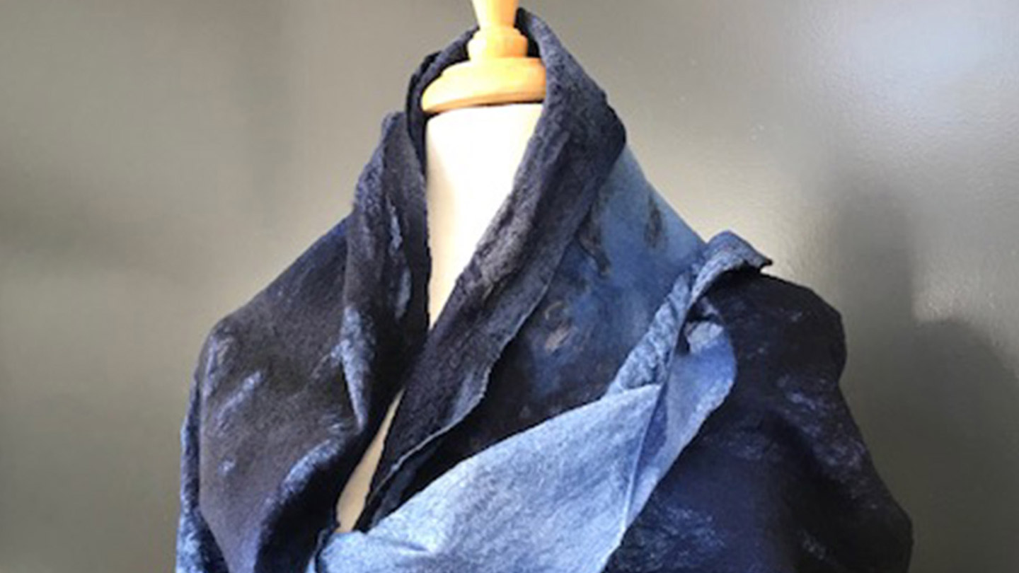 A flowing scarf in blue tones wrapped around a mannequin