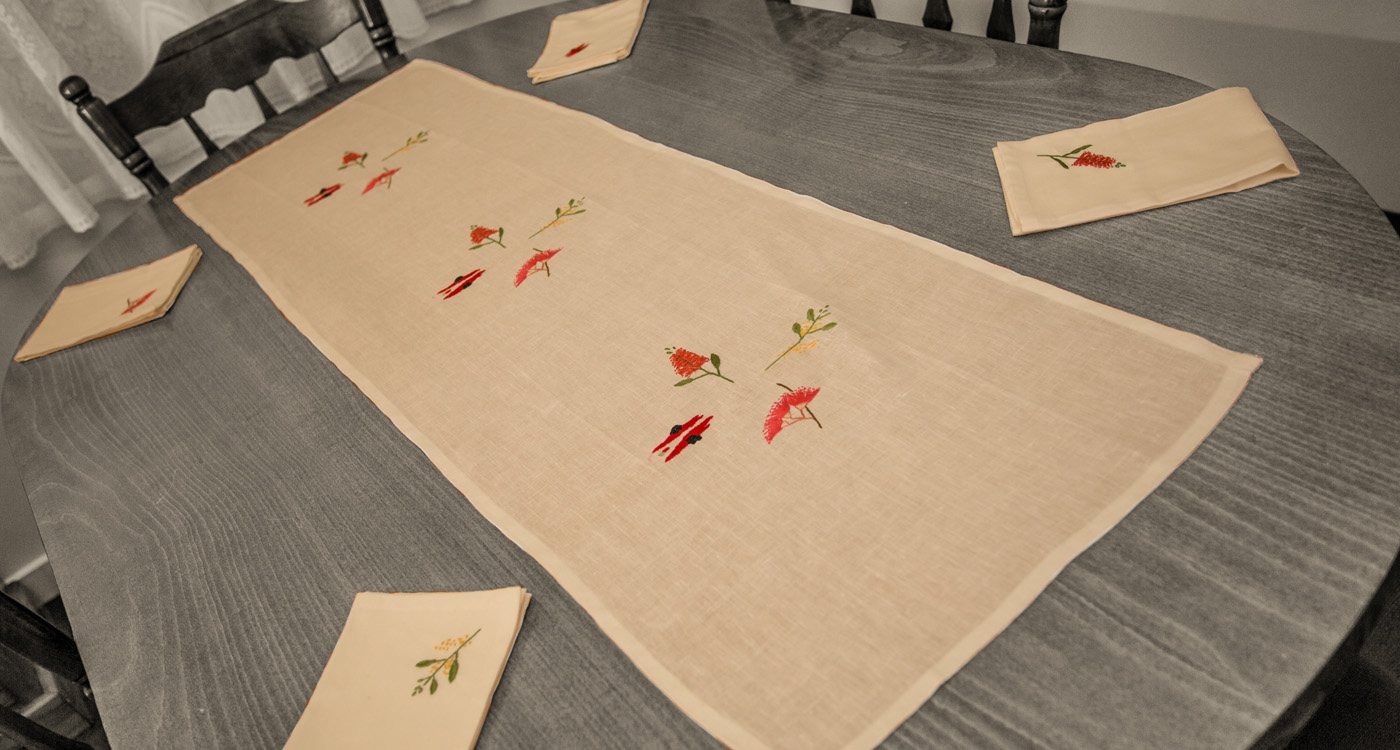 An embroidered table runner and matching napkins. 