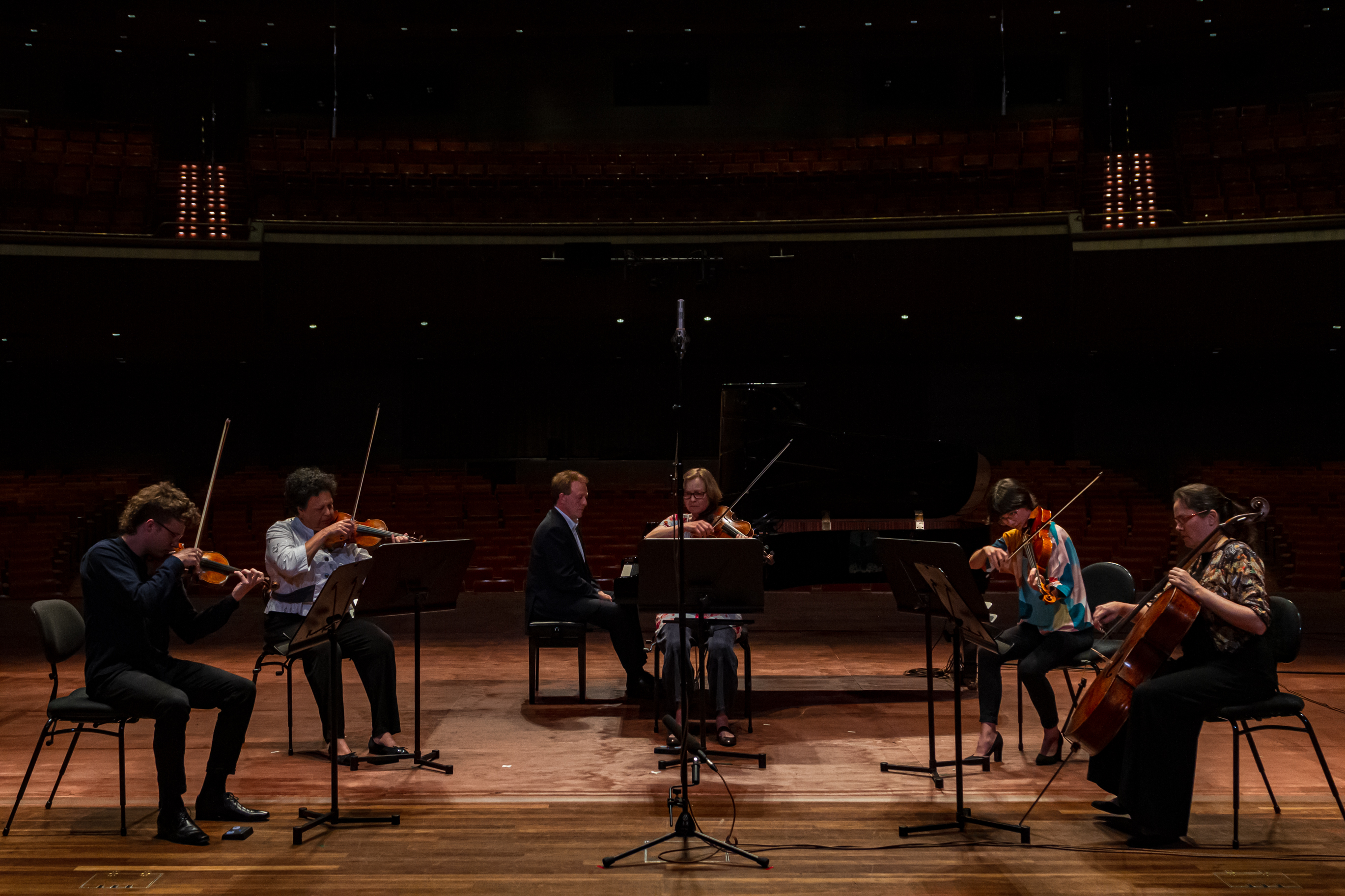 Six performers playing string instruments on the Hamer Hall stage. 